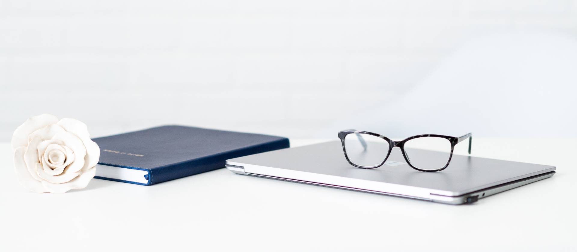 A laptop and glasses on top of a table.