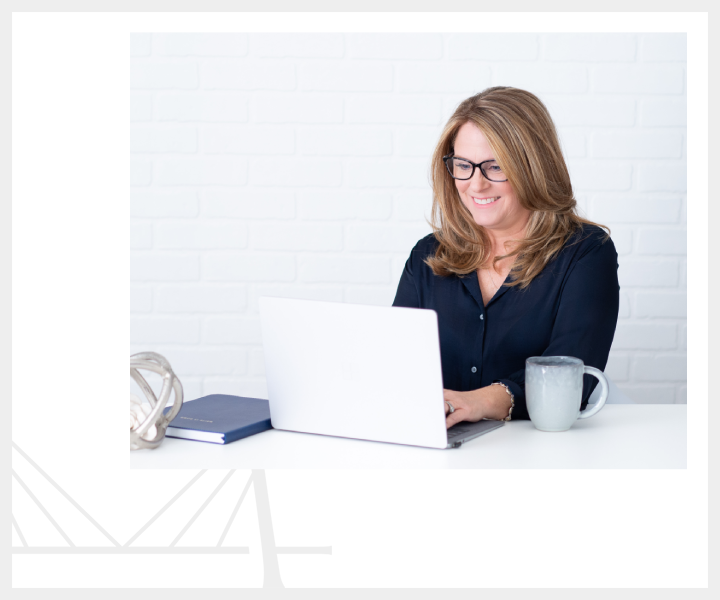 A woman sitting at a table with a laptop.