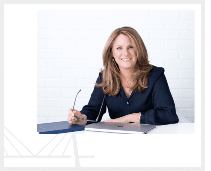 A woman sitting at a table with a pen and paper.