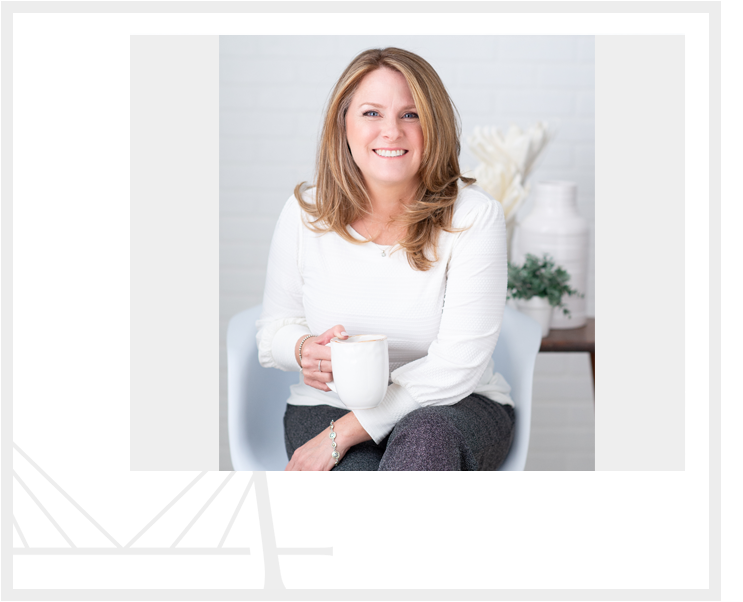 A woman sitting in a chair holding a cup.