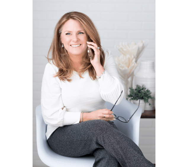 A woman sitting in a chair talking on the phone.