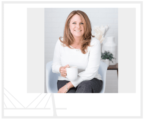 A woman sitting in a chair holding a cup.